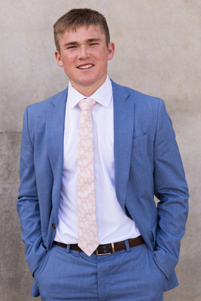 Young man wearing blush palm leaves tie